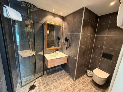 a bathroom with a shower and a sink and a toilet at Hofslund Apartments in Sogndal