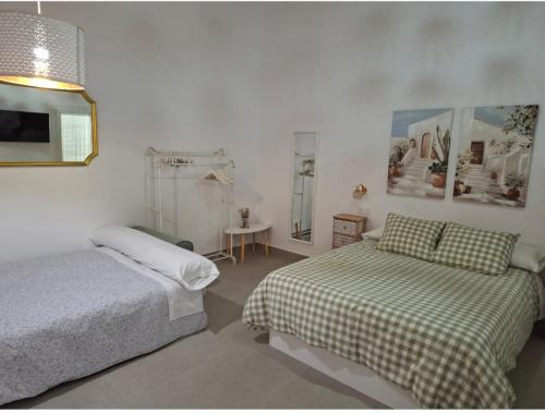 a bedroom with two beds and a mirror at La corrala de la calle Sol in Jerez de la Frontera