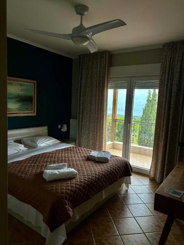 a bedroom with a bed and a large window at Apartment Achilles in Litochoro