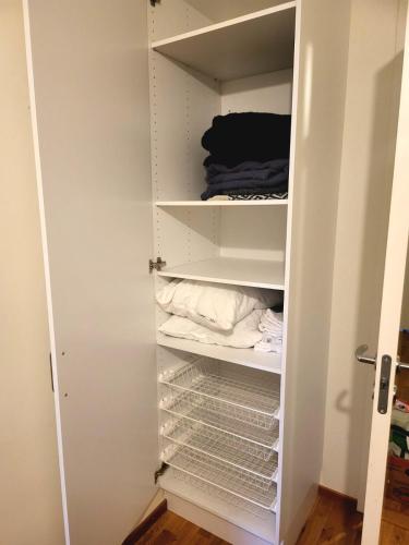 a closet with empty shelves and towels in it at Comfort Us 2 - Cozy Private Home in Uppsala