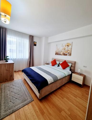 a bedroom with a large bed with red pillows at Rin Elegance Apartament in Bucharest
