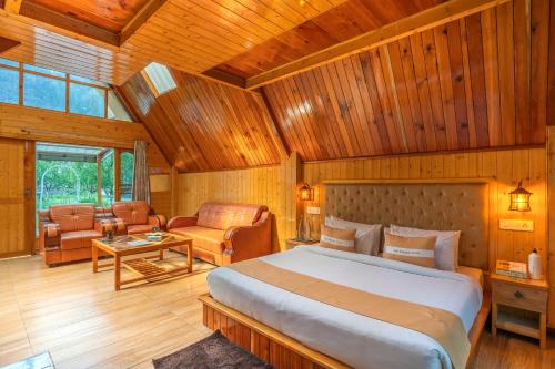 a bedroom with a large bed and a living room at The Social Stays Kasol in Kasol