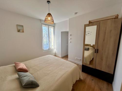 a bedroom with a large bed and a mirror at Le 200 de la cale in Fouesnant