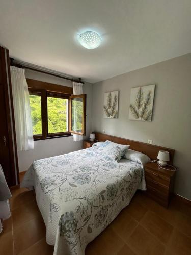 a bedroom with a bed and two windows at El Duje in Tielve