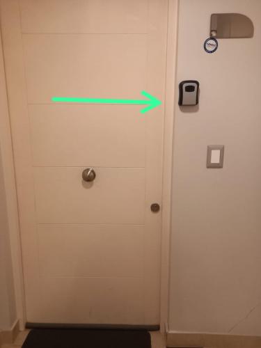 a green arrow is pointing to a door at Departamento Edificio Centro Osorno in Osorno