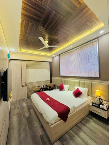 a bedroom with a large bed with red pillows at Fun Square Hotel in Sangrūr