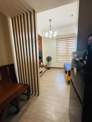 a living room with a table and a room with a partition at Refreshing Condo hotel in General Trias