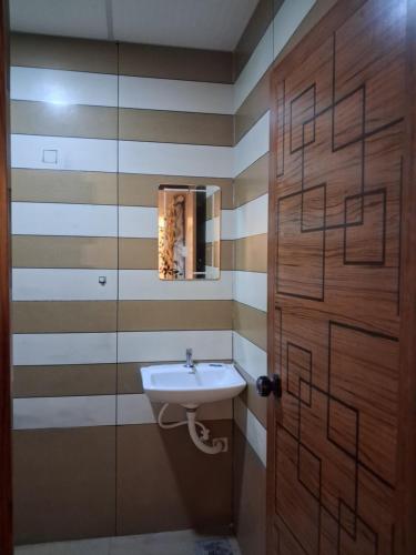 a bathroom with a sink and a wooden door at Love Villa in Kottiyam