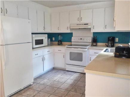 a kitchen with white appliances and white cabinets at Summer Sea Vacation Rental in South Yarmouth