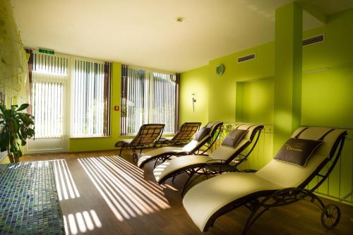 a row of empty chairs in a room with green walls at Naturhotel Hüttenwirt im Grossarltal in Hüttschlag