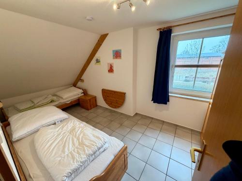 a small bedroom with a bed and a window at Ferienwohnung Matschak OG links in Fehmarn