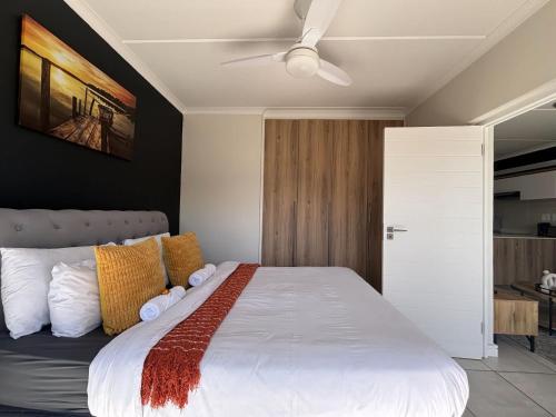 a bedroom with a white bed with a ceiling fan at Onyx Oasis in Ballito