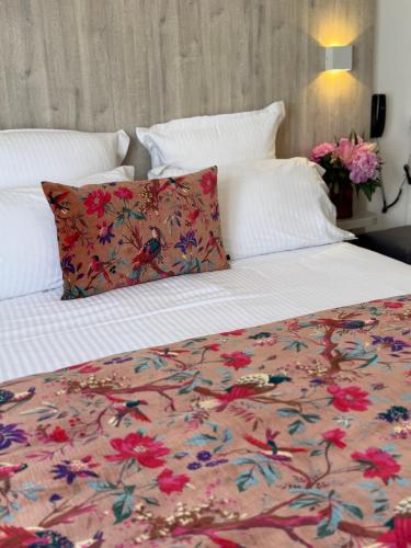 a bedroom with a bed with a floral bedspread at Hotel Provencal in Saint-Raphaël