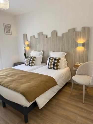 a bedroom with a large bed with a wooden headboard at Hotel Provencal in Saint-Raphaël
