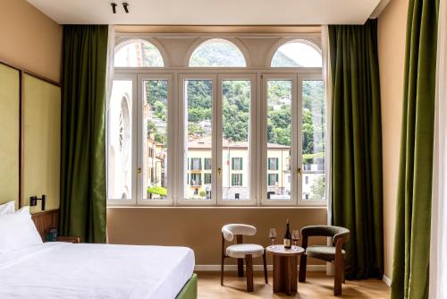 a hotel room with a bed and a large window at Hotel Vapore in Torno