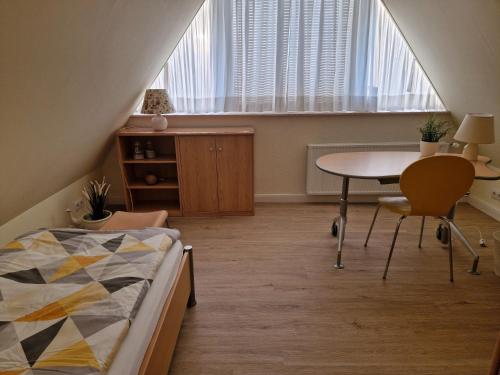 ein Schlafzimmer mit einem Bett, einem Tisch und einem Schreibtisch in der Unterkunft FeWo Hofmann in Schwanewede