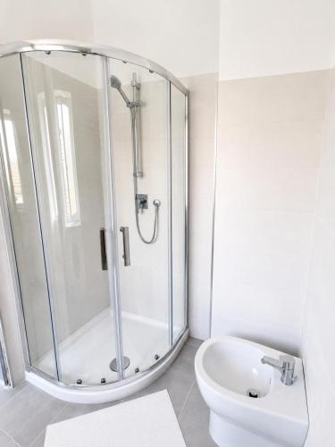 a white bathroom with a shower and a toilet at Ca' Du Marchin, Noli. in Noli