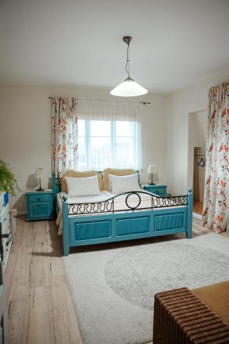 a living room with a blue bed and a window at Guest house ''8 smilgos'' in Klaipėda