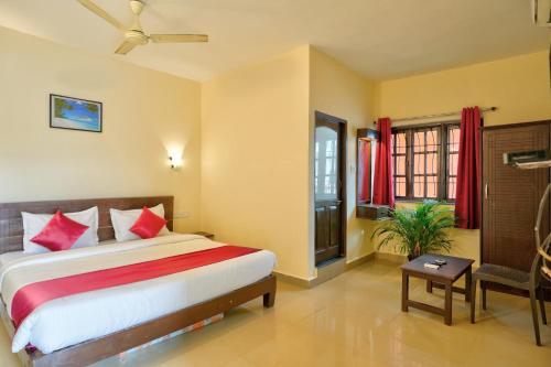 a bedroom with a large bed with red pillows at Hotel Salty Waves Baga in Baga