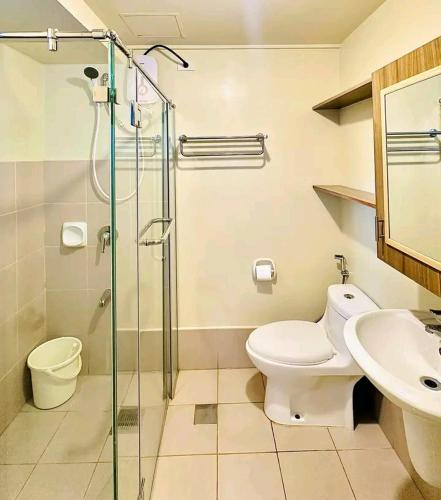 a bathroom with a shower and a toilet and a sink at Ilo2stayAirbnb 1BR Luna in Iloilo City