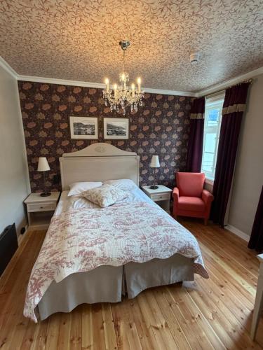 a bedroom with a bed and a chandelier at Hofslund Fjord Hotel in Sogndal