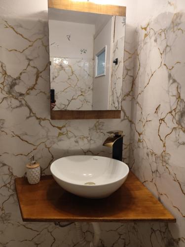 a bathroom with a white sink and a mirror at Asmanis Rooms in Tarti