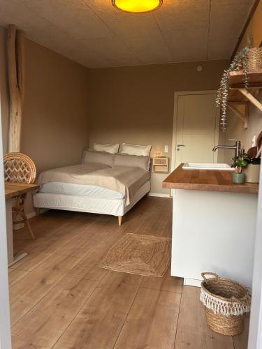 a bedroom with a bed and a sink in it at Hulen - Ro & Natur in Bindslev