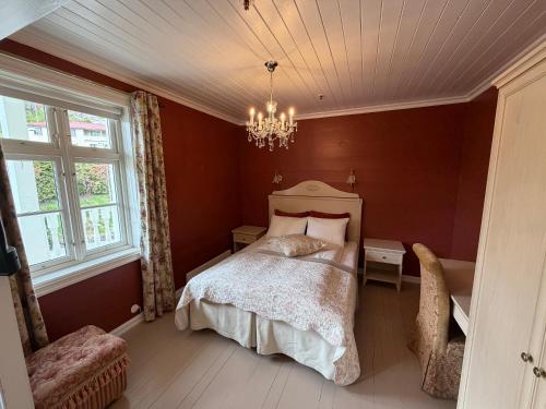 a bedroom with a bed and a chandelier at Hofslund Fjord Hotel in Sogndal