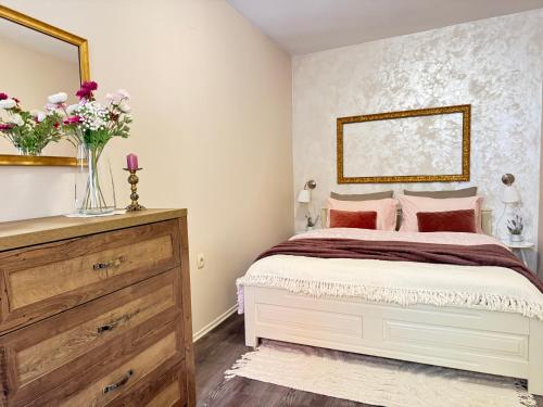 a bedroom with a bed with a vase of flowers at Gloria apartment Rovinj - Heart of Old town - Steps from Sea in Rovinj