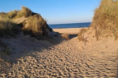 a sandy beach with the ocean in the background at Sandgate retreat hemsby 2023 in Hemsby