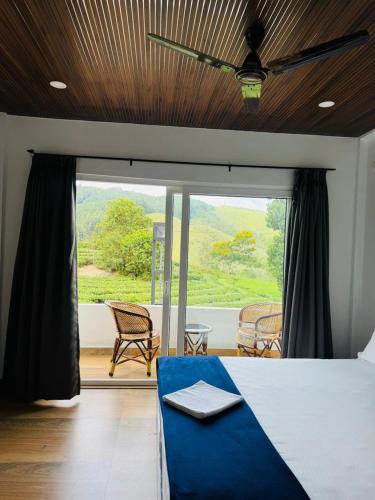 a bedroom with a bed and a large window at Pine Trees Home Holidays in Vagamon