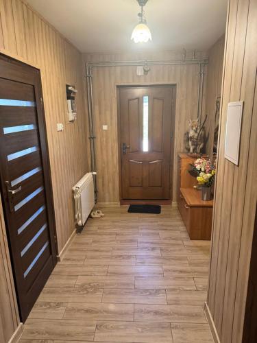 a hallway with a door and a tile floor at Domek u Krzyśka in Słopnice
