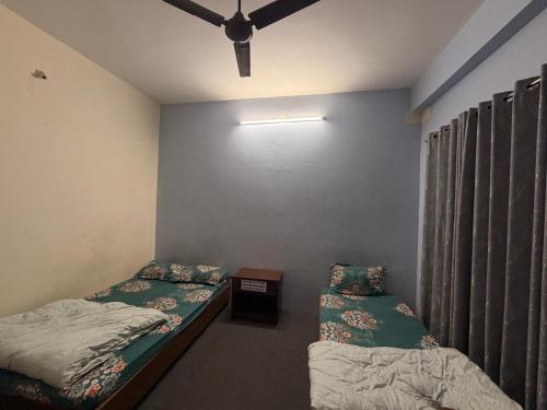 a room with two twin beds and a window at Shree Muktinath Hotel in Pokhara