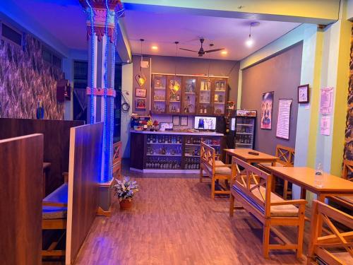 a restaurant with wooden tables and chairs and a counter at Shree Muktinath Hotel in Pokhara