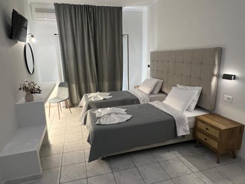 a hotel room with two beds and a television at Prokopis Studios in Laganas