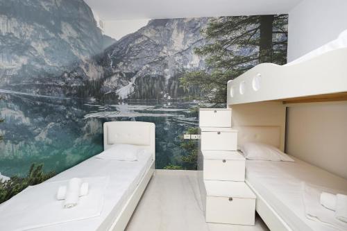 a bedroom with two beds and a mountain mural at Noa Apartments in Vlorë
