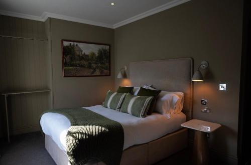 a bedroom with a large bed with green pillows at The George at Backwell in Bristol