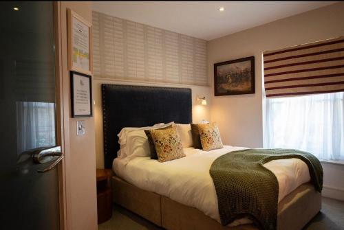 a bedroom with a bed with pillows and a window at The George at Backwell in Bristol