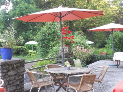 a table and chairs with an umbrella on a patio at Hotel Bellevue in Ayse