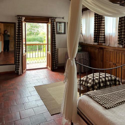 a bedroom with a canopy bed and a sliding glass door at La Tejera de Fausto in Requijada