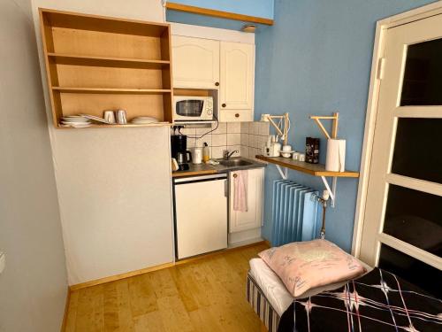 a small kitchen with a refrigerator and a sink at Majatalo Tyrni in Nakkila