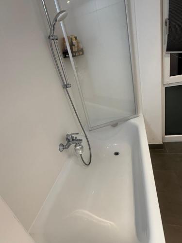 a white bath tub with a faucet in a bathroom at Home Away From Home in Schönefeld