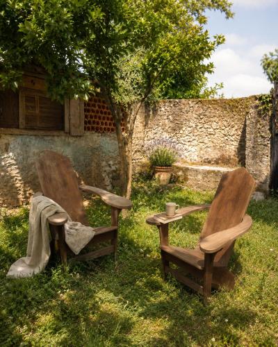 two chairs sitting in the grass next to a tree at Quinta Farm Stay - Silence and Nature Retreat in Lousã