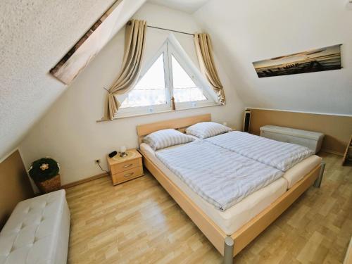 a bedroom with a bed and a large window at Schulstrasse 10a Fewo in Zingst