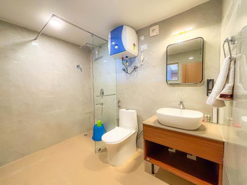 a bathroom with a toilet and a sink and a shower at Hotel Old Bellevue Heritage Stay with Mountain Views in Chowrasta Darjeeling in Darjeeling