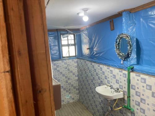 a bathroom with a sink and a blue wall at SaitotiMara Safaris in Sekenani