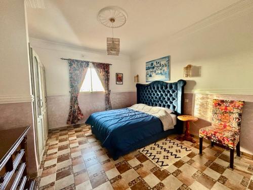 a bedroom with a blue bed and a window at LOUIZA HOUSE, vue imprenable entre lac et désert in Lalla Takerkoust