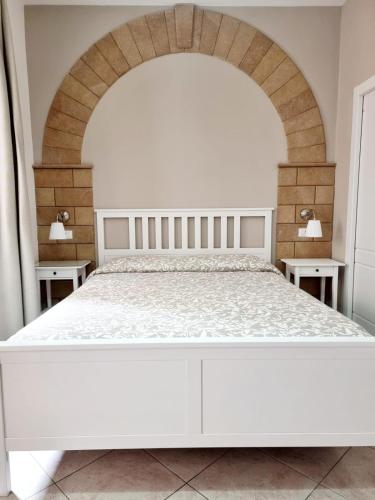a white bed in a bedroom with an archway at Bed and Breakfast Federica in Noto