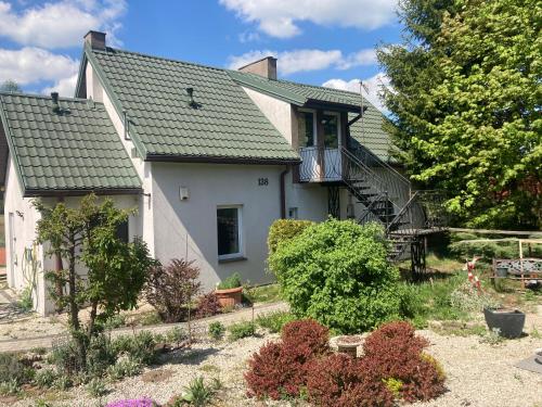 a white house with a green roof at Słoneczny Set in Wólka Klucka