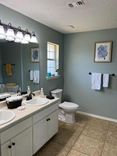 a bathroom with two sinks and a toilet and a mirror at La SeaEsta in Navarre